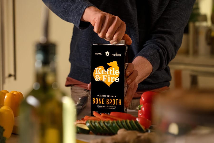 A shopper preparing a meal with Kettle & Fire Classic Chicken Bone Broth
